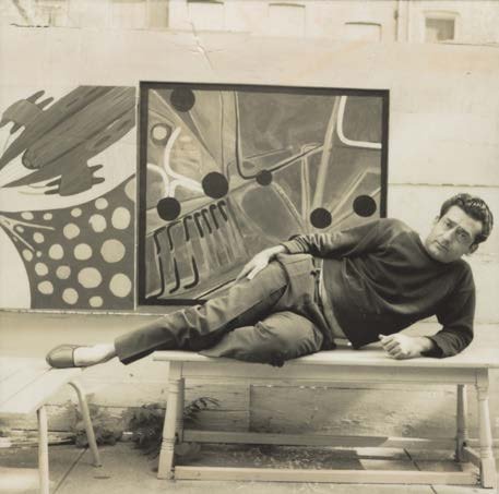 Aref El Rayess reclining on a bench in front of a large abstract painting