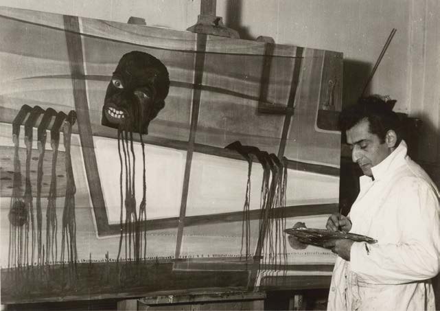 Aref El Rayess at work in his Aley studio in front of a large painting with hanging red drips