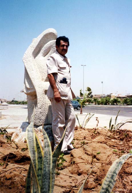 Aref El Rayess standing beside a white sculpture in Jeddah